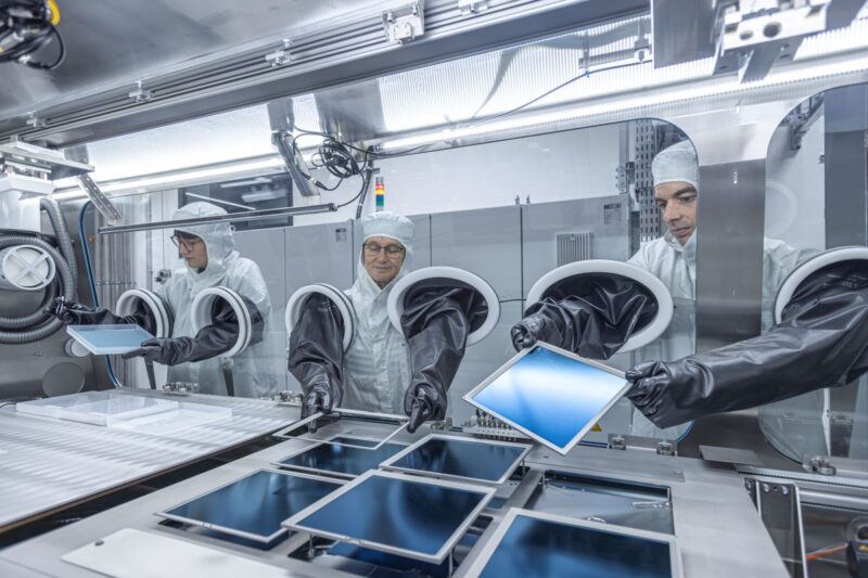Wissenschaftler in Reinraumanzügen und im Labor arbeiten an Siliziumwafern.