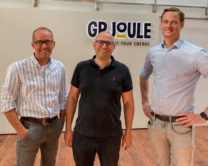 Drei Männer vor einer WAnds mit Schriftzug GP Joule.