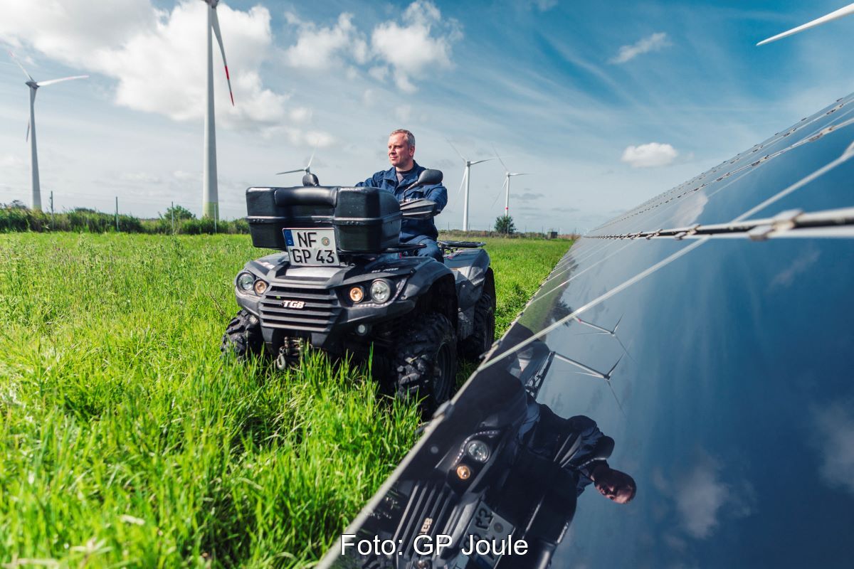 Ein Mann auf einem Quad fährt entlang eines PV-Feldes.