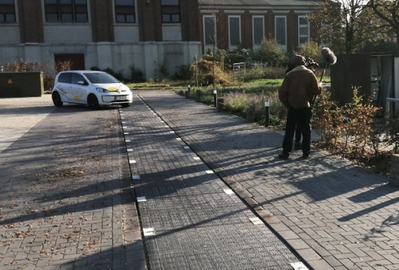 Ein Standbild zeigt wie sich ein Fahrzeug der in einen Parkplatz eingelassenen Solarmodule als Straßenbelag nähert.