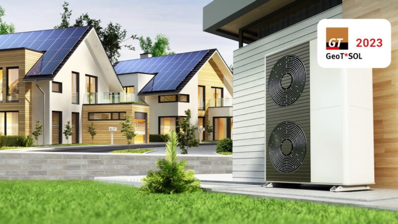 Die Grafik zeigt eine Wärmepumpe und im Hintergrund Häuser mit Photovoltaik-Anlagen auf den Dächern.