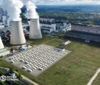 Bild zeigt eine GigaBattery Boxberg 400 3D-Visualisierung vor Kühltürmen auf der grünen Wiese aus der Vogelperspektive.