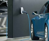 Zu sehen ist der go-e Charger und ein Kabel, der ein blaues E-Auto in einer Tiefgarage lädt.