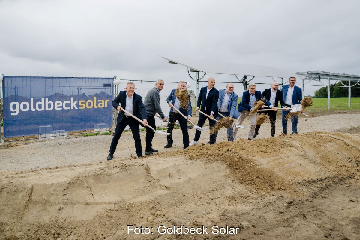 Mehrere Personen bei einem Spatenstich einer vorbereiteten Baustelle.