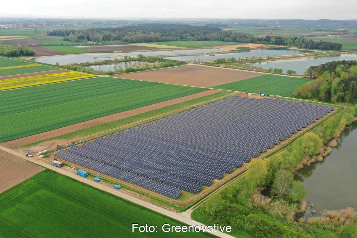 Luftbild eines Solarparks neben Wiesen und Äckern.