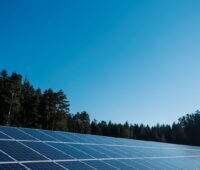 Freiflächensolarpark unter blauem Himmel.