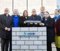Mehrere Personen inklusive Hamburgs 1. Bürgermeister bei der Grundsteinlegung des 100 MW Elektrolyseurs im Hamburger Hafen.
