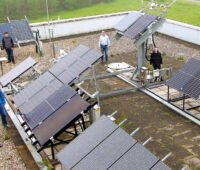 Fünf Mitarbeiter:innen präsentieren Photovoltaik-Teststand auf einem Dach der Hochschule Gelsenkirchen, wo auch bifaziale PV-Module getestet werden.