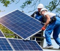 Zwei Monteure installieren eine Solaranlage, Photovoltaik erfordert keinen zusätzlichen Netzausbau.