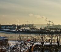 Blick vom Altonaer Balkon über den Hamburger Hafen im Winter. Schornsteine qualmen.