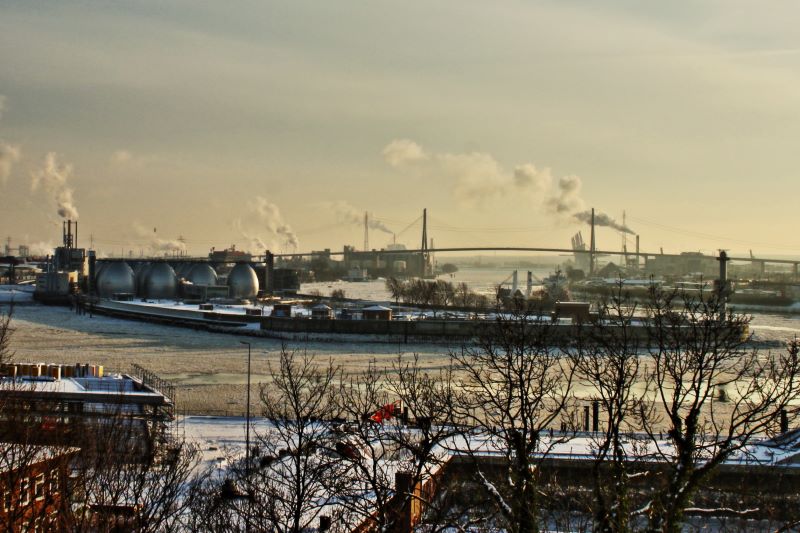 Blick vom Altonaer Balkon über den Hamburger Hafen im Winter. Schornsteine qualmen.