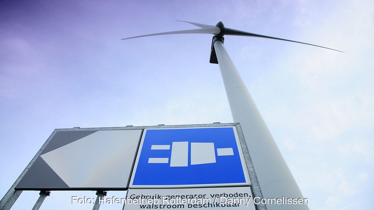 Zu sehen ist eine Windkraftanlage und ein Hinweisschild zur Landstromanlage mit Windenergie im Rotterdamer Hafen.