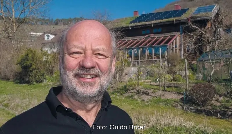 Hans-Josef Fell vor einem Haus mit Photovoltaik auf dem Dach. Eine Analyse zeigt: Erneuerbare erobern Weltenergiemärkte.