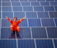 Zu sehen ist ein Arbeiter inmitten von PV-Modulen. Größter Solarpark Europas bei Leipzig geplant.