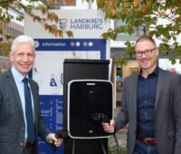 Zwei Männer des Landkreises Harburg mit Ladekabeln für E-Autos.