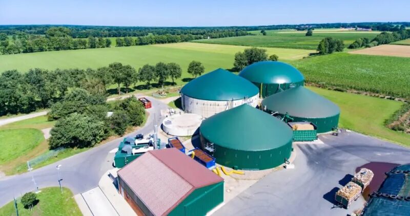 Luftbild von Biogas-Anlage mit grünen Gebäuden.