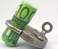 Symbolbild für Haushaltssperre: 100-Euro-Scheine in Vorhängeschloss gewickelt