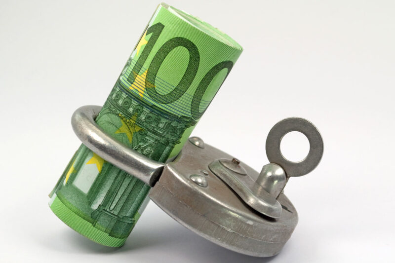 Symbolbild für Haushaltssperre: 100-Euro-Scheine in Vorhängeschloss gewickelt
