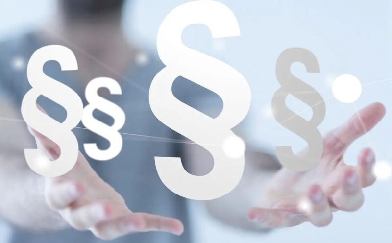 Im Bild zwei Hände mit mehreren Paragrafen als Symbol für die Energierechtsnovelle Strom.