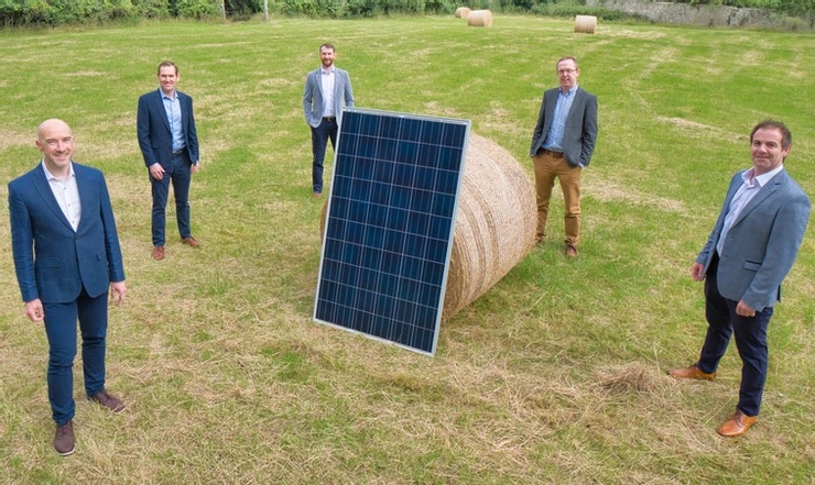 Zu sehen ist das Team von Highfield Solar auf einem Acker mit Photovoltaik-Modul.