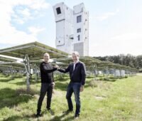 Zu sehen sind Helikon-Geschäftsführer Patrick Hilger und Synhelion-CEO Gianluca Ambrosetti in einem CSP-Spiegelfeld für hochkonzentrierende Solartechnologie mit dem Solarturm im Hintergrund.