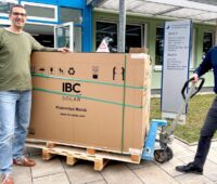 Im Bild zwei Männer mit Ameise und einer Palette mit PV-Modulen für die DGS Solarschule Nürnberg.