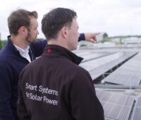 Zu sehen sind zwei Menschen auf einem Hallendach mit Photovoltaik als Sinnbild für die Abteilung Commercial Energy Systems.