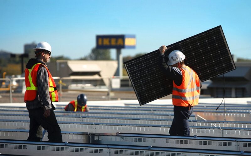 Photovoltaik-Montage auf einem IKEA-Dach. Das IKEA Jetzt gehört zu Solstråle auch eine Ladestation für Elektoautos.