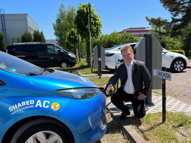 Ein Mann schließt ein E-Mobil an das Ladenetz an.