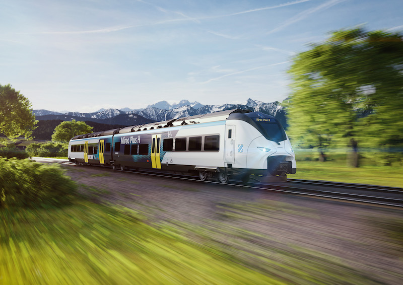 ein Zug mit Bayern-Logo vor einer Berglandschaft