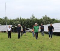 Personen, die für Bürgerenergie stehen, posieren vor Freiflächenparks.