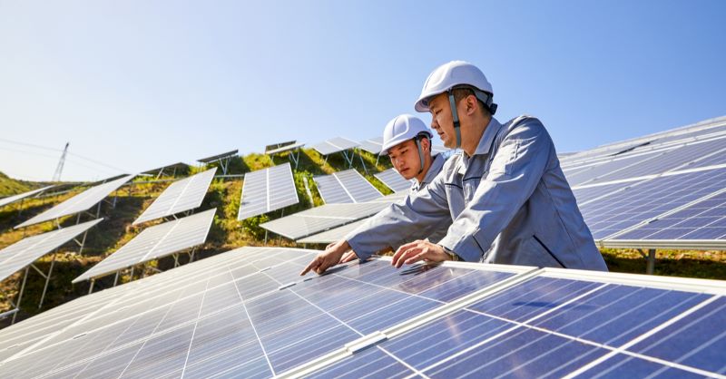 Zwei asiatische Projektentwickler in einer Photovoltaikanlage,