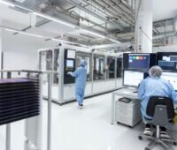 Reinraum-Labor mit Arbeitenden in Reinraumanzügen.