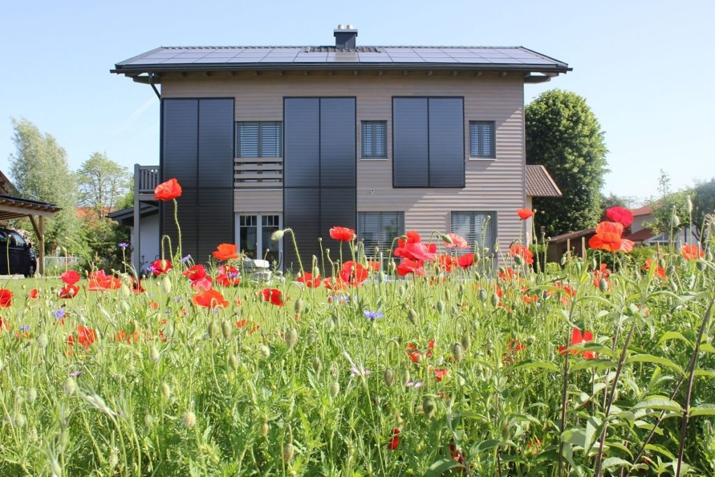 Zu sehen sind Solarthermie Kollektoren einer Solarheizung, die an der Fassade eines Hauses montiert sind.