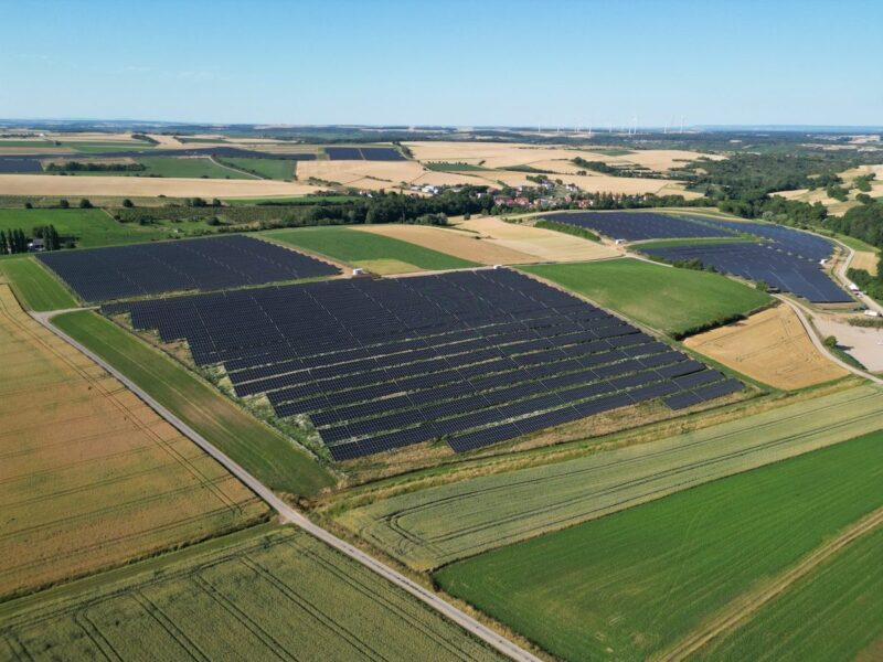 Solarpark aus der Vogelperspektive zwischen landwirtschaftlichen Flächen gelegen.