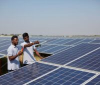 Zwei Männer in einem großen Solarpark in Indien.