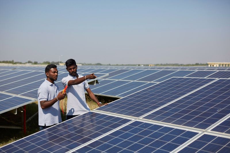 Zwei Männer in einem großen Solarpark in Indien.