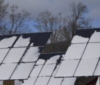 Im Bild schneebedeckte Photovoltaik-Module, eine Oberflächenversiegelung soll Eisbildung verringert und das Abtauen verbessern.