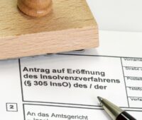 ein Stempel und ein Formular für einen Insolvenz-Antrag