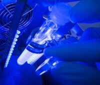 In blauer Umgebung ist ein Reagenzglas heller erleuchtet.