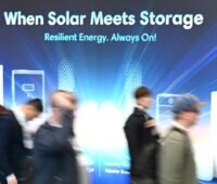 Text im Bild auf dem Messebesucher vor einem Speicherstand vorbeilaufen: When Solar meets Storage. Resilent Energy. Always on!