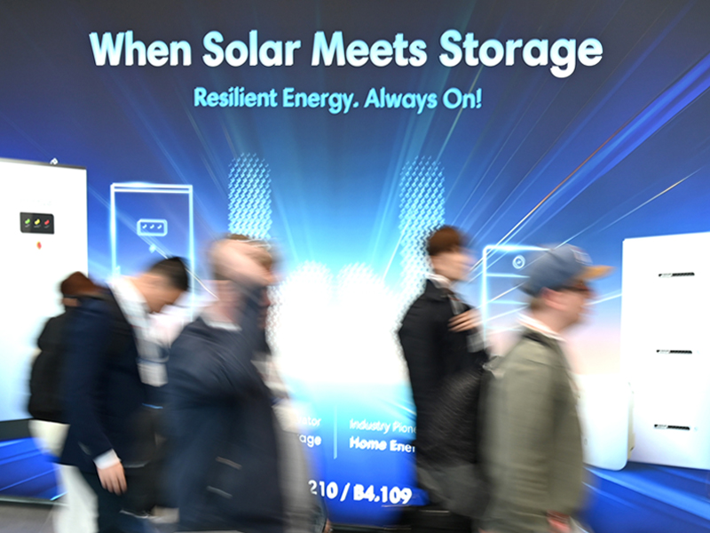 When Solar Meets Storage. Resilent Energy. Always On!. Zu sehen sind Menschen die vor einem großen Plakat mit obiger Überschrift vorbeilaufen.