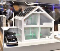 Messestand mit Modellhaus, PV-Anlage udn E-Auto.