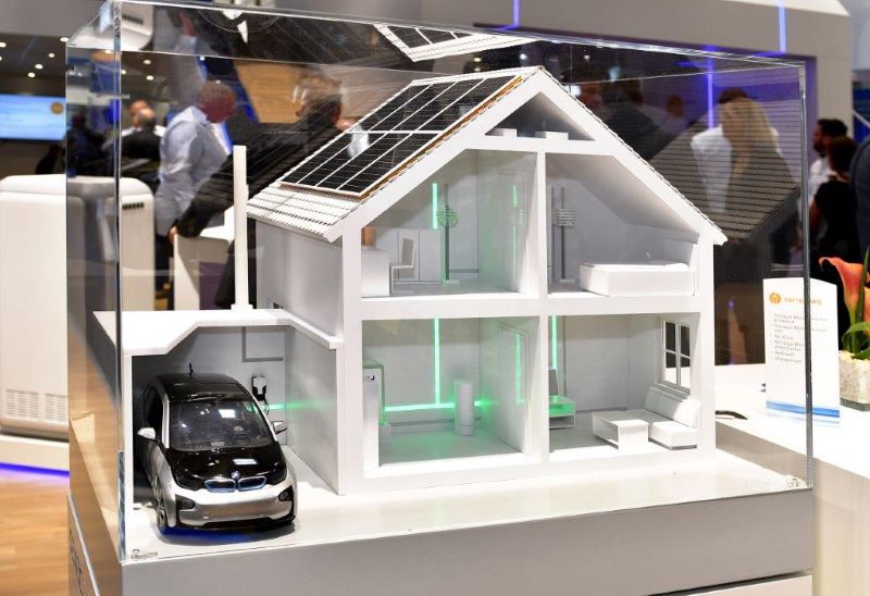 Messestand mit Modellhaus, PV-Anlage udn E-Auto.