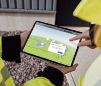 Zwei Personen halten ein Pad mit der Darstellung eines Onlinetools für die Direktvermarktung