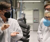 Zu sehen sind Professor Helge Stein und Ministerin Theresia Bauer, die ein autonomes Forschungslabor für die Batterieforschung einweihen.
