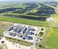 Luftbild zeigt Chemieanlage mit ausgedehntem PV-Park nebenan.