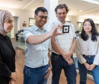 Zwei Männer und zwei Frauen mit einer Solarzelle::Gruppenfoto des Forschungsteams an der KAUST, das die Stabilität von Perowskit-Zellen nachwies.