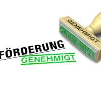 Unter dem Wort Förderung steht in Grün gestempelt "Genehmigt" als Symbol für die Effizienzhaus 55-Plus-Förderung. Daneben liegt der dazugehörige Genehmigt-Stempel.