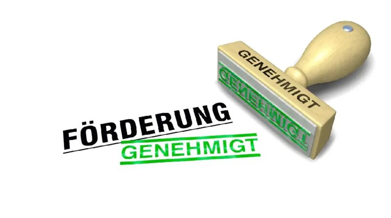 Unter dem Wort Förderung steht in Grün gestempelt "Genehmigt" als Symbol für die Effizienzhaus 55-Plus-Förderung. Daneben liegt der dazugehörige Genehmigt-Stempel.